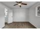 Bedroom with wood-look floors, a window, ceiling fan, and access to bathroom at 1006 E Weber Dr, Tempe, AZ 85288