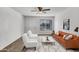 Bright living room with an orange couch and white chairs, with big windows and a fan at 1006 E Weber Dr, Tempe, AZ 85288