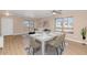 Bright, staged living room with wood floors, a ceiling fan, large windows, and a dining table at 10461 E Birchwood Ave, Mesa, AZ 85208