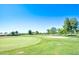 Scenic view of a golf course with green grass, trees, and houses in the distance at 107 Leisure World --, Mesa, AZ 85206