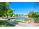 Scenic view of a pond with a fountain, trees, and houses in the distance at 107 Leisure World --, Mesa, AZ 85206