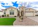 Charming single-story home with desert landscaping, artificial grass, and a two-car garage at 11721 W Parkway Ln, Avondale, AZ 85323