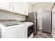 Functional laundry room with Samsung washer and dryer and stainless steel refrigerators at 11721 W Parkway Ln, Avondale, AZ 85323