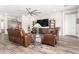 Spacious living room with leather recliners, a ceiling fan, and built-in shelving at 11721 W Parkway Ln, Avondale, AZ 85323