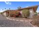 Home exterior showcasing beautiful pink bougainvillea, lush green shrubs, and natural stone walkway at 13235 W Ashwood Dr, Sun City West, AZ 85375