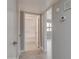 Hallway with tile floors leading to bathroom with tub-shower and room with window at 13235 W Ashwood Dr, Sun City West, AZ 85375