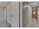 Bright hallway featuring doors, wood-look flooring, and thermostat on wall at 13235 W Ashwood Dr, Sun City West, AZ 85375