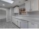 Bright kitchen featuring white cabinets, tile backsplash, and a double basin sink under a window at 13235 W Ashwood Dr, Sun City West, AZ 85375