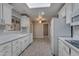 Well-lit kitchen boasts white cabinets, a skylight, and stainless steel appliances at 13235 W Ashwood Dr, Sun City West, AZ 85375