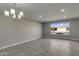 A spacious living area features contemporary lighting, gray walls, and views of the serene neighborhood at 13235 W Ashwood Dr, Sun City West, AZ 85375