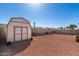 Spacious backyard featuring a storage shed, block fence, and desert landscaping for low maintenance at 1339 E Silverbrush Trl, Casa Grande, AZ 85122