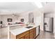 Open kitchen with counter seating, wood cabinets, stainless steel appliances, and a view into the living room at 1339 E Silverbrush Trl, Casa Grande, AZ 85122