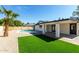 Lush backyard with an artificial lawn, a pool, desert landscaping and covered patio at 1504 E Jasmine St, Mesa, AZ 85203