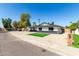 Attractive single-story home featuring desert landscaping, a small lawn, and a modern black and white color scheme at 1504 E Jasmine St, Mesa, AZ 85203