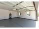 Garage interior featuring epoxy flooring, water heater, and natural light from two windows at 1504 E Jasmine St, Mesa, AZ 85203