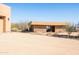 Exterior view of the tan barn with stone accents and light tan stucco walls under a clear blue sky at 16835 E Skinner Dr, Rio Verde, AZ 85263