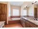 Bathroom featuring double sinks, tile surround garden tub, granite countertops, and wooden cabinetry at 16835 E Skinner Dr, Rio Verde, AZ 85263