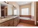 Bright bathroom with double sink vanity with granite countertops, and a separate soaking tub at 16835 E Skinner Dr, Rio Verde, AZ 85263