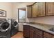 Laundry room featuring front load washer and dryer, granite countertops, and custom cabinetry at 16835 E Skinner Dr, Rio Verde, AZ 85263