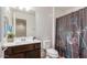 Bathroom features a vanity with a dark wood cabinet, decorative mirror, and a shower/tub with a floral curtain at 1950 N Center St # 111, Mesa, AZ 85201