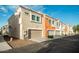 Exterior shot of townhome featuring tan and beige stucco, well-maintained landscaping, and private garages at 1950 N Center St # 111, Mesa, AZ 85201