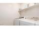 Bright laundry area with modern white washer and dryer, a shelf above, and clean white walls at 1950 N Center St # 111, Mesa, AZ 85201