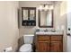 Traditional-style bathroom featuring a granite countertop, dark wood cabinetry, and storage above toilet at 20212 E Appaloosa Dr, Queen Creek, AZ 85142