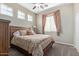 Comfortable bedroom with a ceiling fan, patterned bedding, and natural light from two windows at 20212 E Appaloosa Dr, Queen Creek, AZ 85142