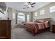 Comfortable main bedroom with a ceiling fan, large windows, and a wood bed frame at 20212 E Appaloosa Dr, Queen Creek, AZ 85142