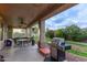 Covered patio with a grill, table, chairs, ceiling fans and grassy backyard, perfect for outdoor entertaining at 20212 E Appaloosa Dr, Queen Creek, AZ 85142