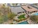 An aerial shows the backyard with a pool, lush green area, mature landscaping, and outdoor patio with a fire pit and spa at 2025 W Calle Del Sol --, Phoenix, AZ 85085