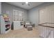 Bright bedroom featuring a crib, changing table, plantation shutters, and a ceiling fan at 2025 W Calle Del Sol --, Phoenix, AZ 85085