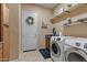 Well-lit laundry room with modern appliances, floating shelves, and ample storage space at 2025 W Calle Del Sol --, Phoenix, AZ 85085