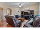 Comfortable living room with leather seating, ceiling fan, and wood-style flooring at 2025 W Calle Del Sol --, Phoenix, AZ 85085