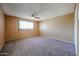 Carpeted bedroom with a ceiling fan and window bringing in natural light at 2144 W Joan De Arc Ave, Phoenix, AZ 85029