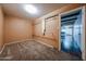 Bedroom with neutral carpet and access to the kitchen, providing ample closet space at 2144 W Joan De Arc Ave, Phoenix, AZ 85029