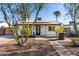 Charming single-story home with a brick pathway, complemented by mature landscaping and a well-maintained front yard at 2205 N 22Nd St, Phoenix, AZ 85006