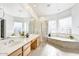 Bright bathroom featuring double sinks, tub, a walk-in shower with glass blocks at 22503 N 76Th Pl, Scottsdale, AZ 85255