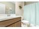 Bathroom showcasing a wooden vanity, white sink, and a tub with a blue curtain at 24029 W Zak Rd, Buckeye, AZ 85326