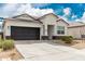 Well-maintained single-story home with a dark grey two-car garage and easy desert landscaping at 24029 W Zak Rd, Buckeye, AZ 85326