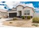 Well-maintained single-story home with a dark grey two-car garage and easy desert landscaping at 24029 W Zak Rd, Buckeye, AZ 85326