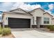 Charming single-story home featuring a dark grey two-car garage and a low-maintenance desert landscape at 24029 W Zak Rd, Buckeye, AZ 85326