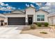 Well-maintained single-story home with a dark grey two-car garage and easy desert landscaping at 24029 W Zak Rd, Buckeye, AZ 85326