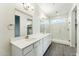 Bathroom featuring double sink vanity, large mirror, and glass-enclosed shower at 24959 S 190Th Dr, Buckeye, AZ 85326