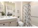 Well-lit bathroom with a combination shower and tub featuring a modern vanity and decorative shower curtain at 26231 W Maple Dr, Buckeye, AZ 85396