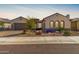 Charming single-story home featuring a meticulously landscaped front yard with desert plants and unique stone accents at 26231 W Maple Dr, Buckeye, AZ 85396