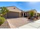 Attractive home with a brick driveway, two-car garage, and desert landscaping in the front yard at 26231 W Maple Dr, Buckeye, AZ 85396