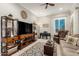 Relaxing living room featuring a piano, comfortable chair, display shelves, and a large window with natural light at 26231 W Maple Dr, Buckeye, AZ 85396