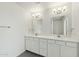 Bathroom featuring double sink vanity, framed mirrors, and wood-look tile flooring at 2744 S 357Th Dr, Tonopah, AZ 85354