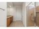 Bathroom featuring granite vanity, framed mirrors, and glass-enclosed shower with natural tile at 26905 W Mcrae Dr, Buckeye, AZ 85396